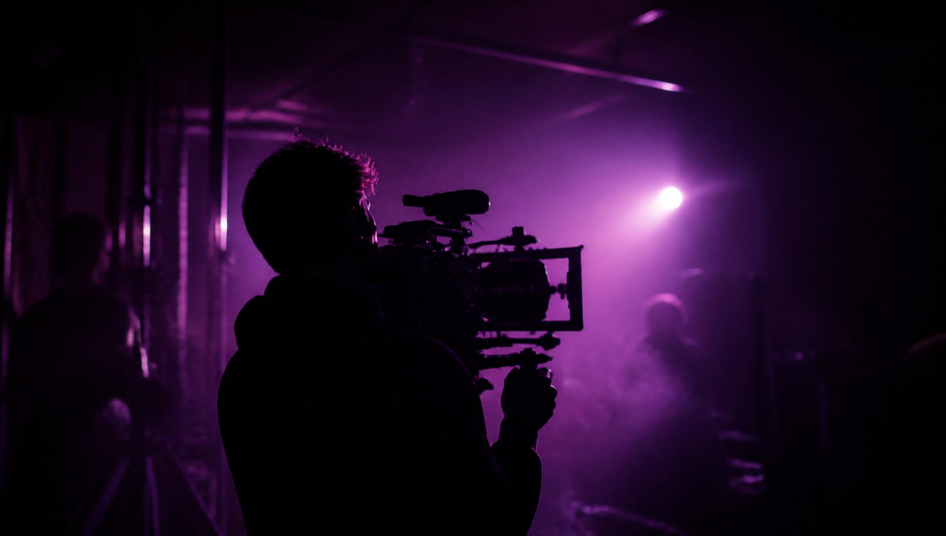 FILMERA crew on a dark set lit with brand purple light